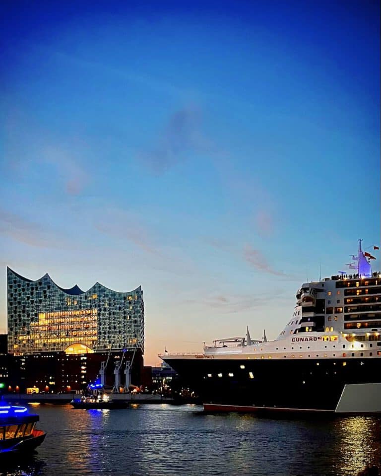 Luxus-Yacht im Hafen bei Sonnenuntergang, modernes Design und maritime Atmosphäre.